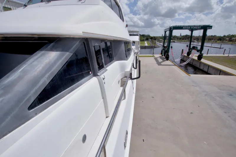 Slide: The Image of 1998 Lazzara 76 Skylounge Grand Salon yacht docked at marina under cloudy sky. - 80