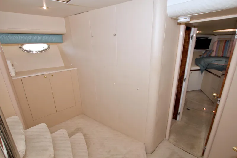 Slide: The Image of Interior of 1998 Lazzara 76 Skylounge Grand Salon yacht, featuring stairs and cabin entrance. - 87