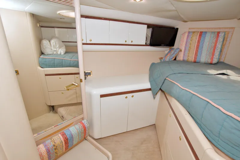 Slide: The Image of Interior cabin of 1998 Lazzara 76 Skylounge Grand Salon yacht, featuring cozy bedding and storage. - 93