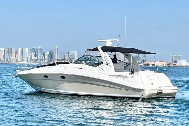 The Image of 2005 Sea Ray 390 Sundancer yacht cruising near city skyline on a sunny day. - 0