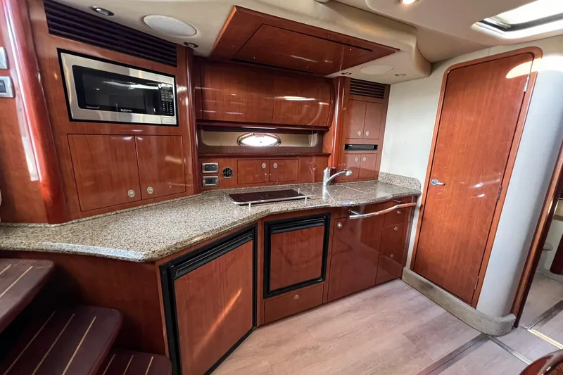 Slide: The Image of 2005 Sea Ray 390 Sundancer yacht kitchen with wood cabinetry and modern appliances. - 25