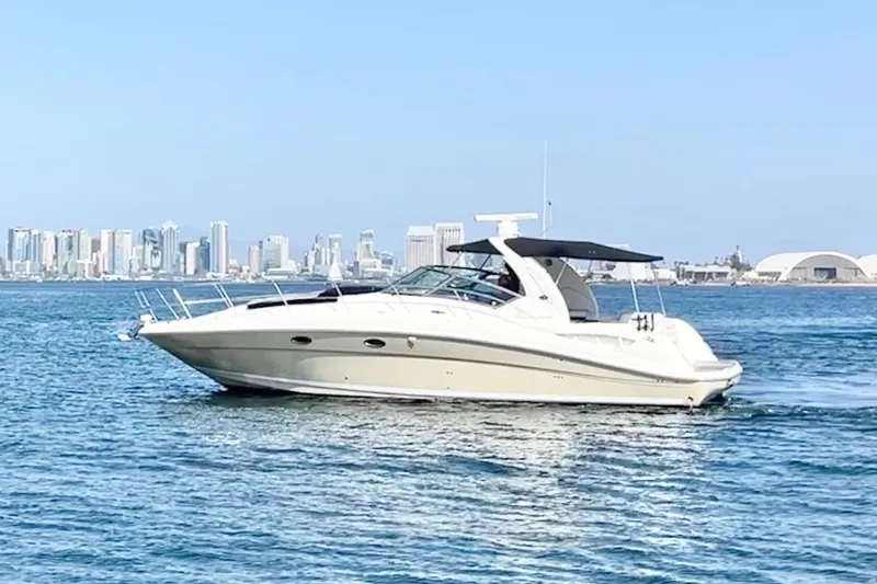 Slide: The Image of 2005 Sea Ray 390 Sundancer cruising on water with city skyline in background. - 3