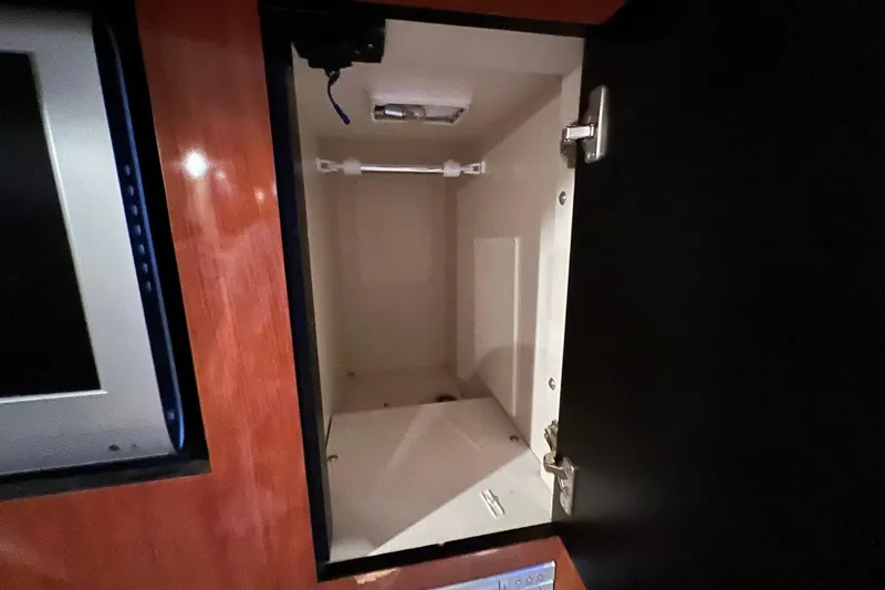 Slide: The Image of Open cabinet inside 2005 Sea Ray 390 Sundancer yacht, showcasing interior storage space. - 34