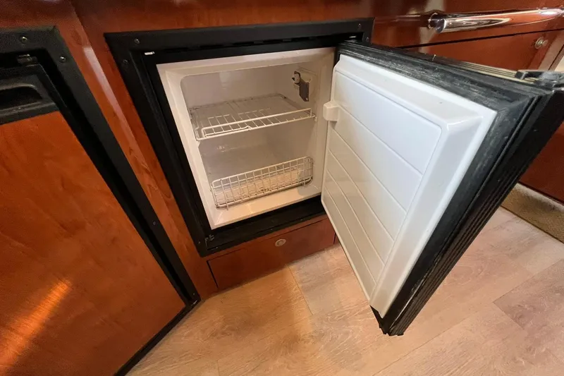 Slide: The Image of Open refrigerator in 2005 Sea Ray 390 Sundancer yacht, showcasing interior shelves. - 42