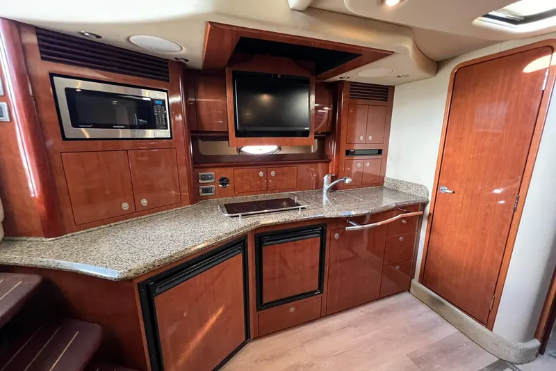 Slide: The Image of Luxurious 2005 Sea Ray 390 Sundancer yacht kitchen with wood cabinetry and modern appliances. - 44