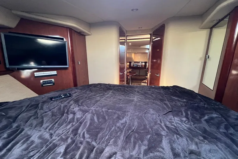 Slide: The Image of Luxurious interior of 2005 Sea Ray 390 Sundancer yacht with TV and plush bedding. - 50