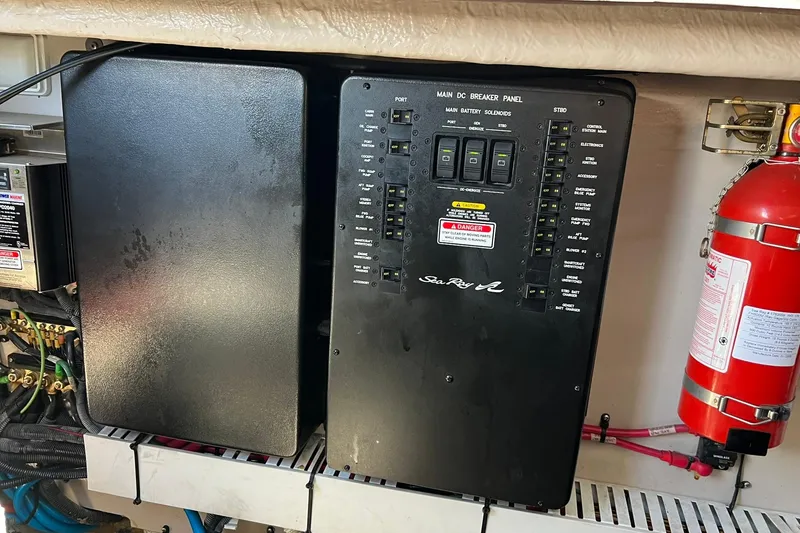 Slide: The Image of Main DC breaker panel on 2005 Sea Ray 390 Sundancer boat, with fire extinguisher nearby. - 58