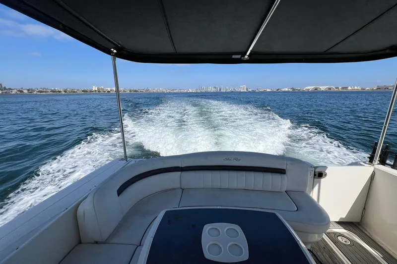 Slide: The Image of 2005 Sea Ray 390 Sundancer cruising on open water with city skyline in background. - 6