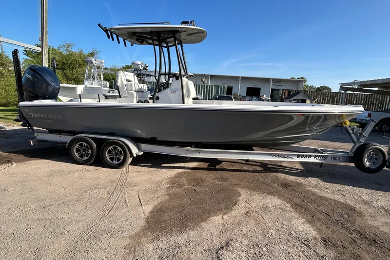 The Image of 2023 Pathfinder 2600 HPS boat on trailer, parked outdoors under clear blue sky. - 1