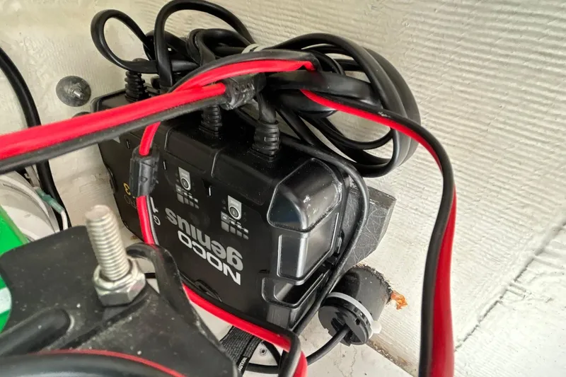 Slide: The Image of Battery charger with red and black cables on a 2023 Pathfinder 2600 HPS boat. - 26