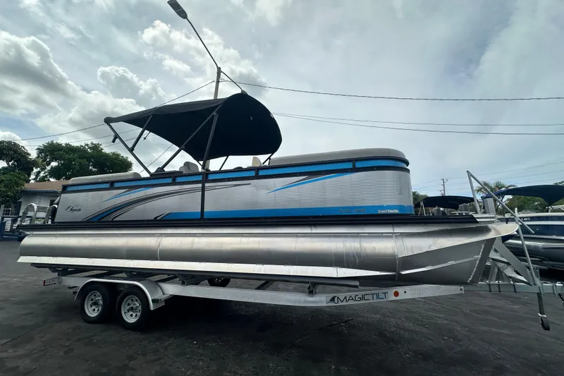 Slide: The Image of 2022 Qwest LTZ 824 pontoon boat with canopy on trailer, parked outdoors. - 12