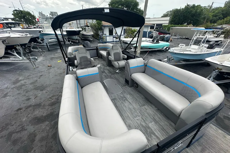 Slide: The Image of Pontoon boat Qwest LTZ 824, 2022 model, with spacious seating and canopy, docked at marina. - 13