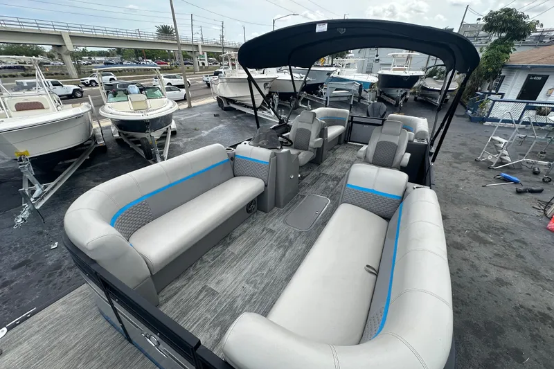 Slide: The Image of 2022 Qwest LTZ 824 pontoon boat with spacious seating, docked among other boats. - 14