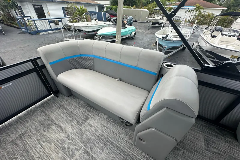 Slide: The Image of 2022 Qwest LTZ 824 boat interior with gray seating and blue accents, docked near other boats. - 23