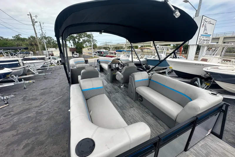 Slide: The Image of 2022 Qwest LTZ 824 pontoon boat with spacious seating and canopy in a marina setting. - 26