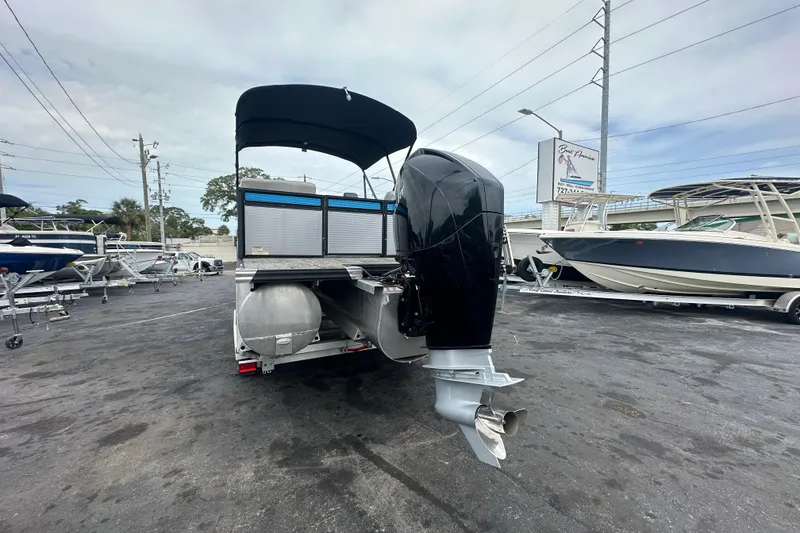 Slide: The Image of 2022 Qwest LTZ 824 pontoon boat with outboard motor in a marina setting. - 8