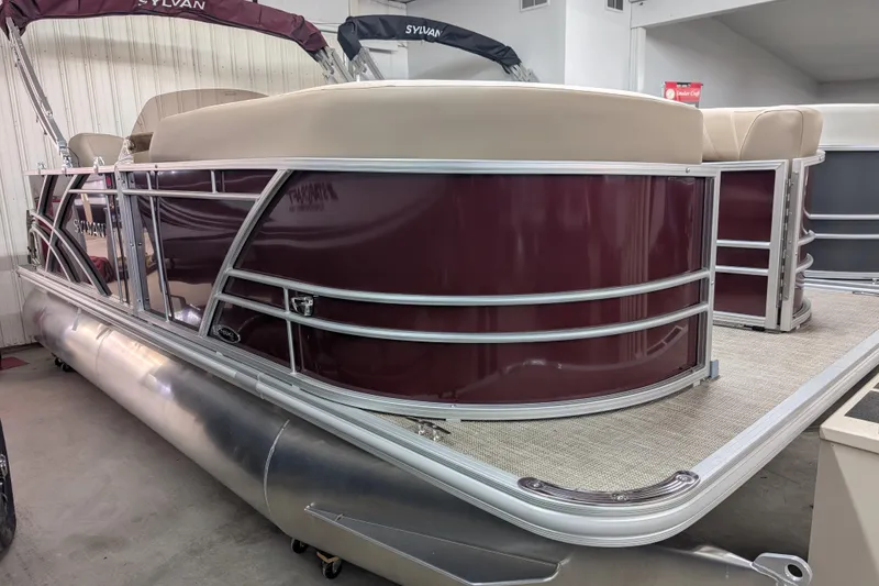 The Image of 2026 Sylvan Mirage 818 Cruise pontoon boat in showroom, featuring maroon and beige design. - 0