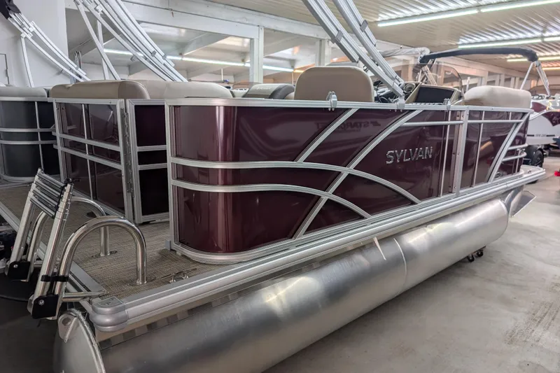 Slide: The Image of 2026 Sylvan Mirage 818 Cruise pontoon boat in showroom, featuring sleek maroon design. - 1