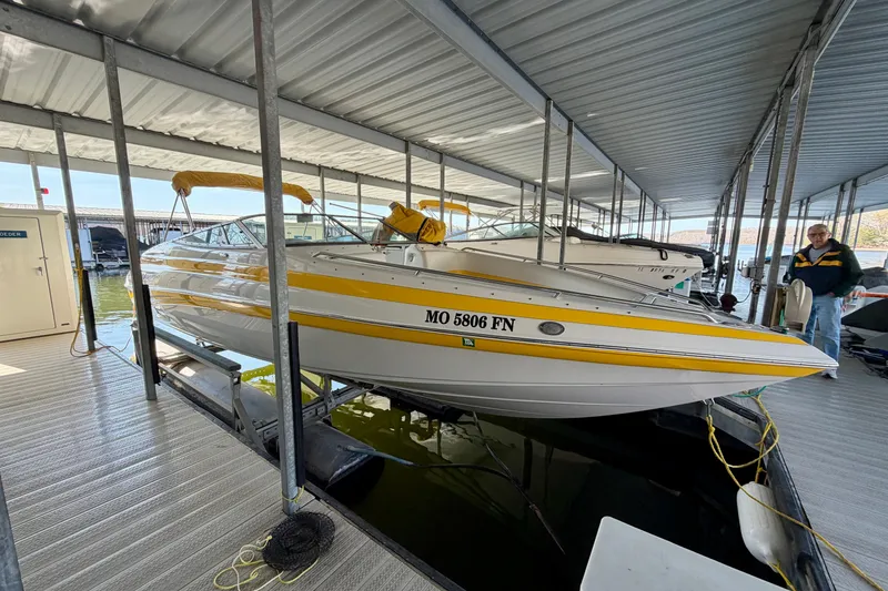 Slide: The Image of 2006 Crownline 266 BR boat docked in a covered marina, featuring yellow accents. - 1