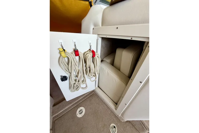 Slide: The Image of Storage compartment with ropes and cushions in a 2006 Crownline 266 BR boat. - 22