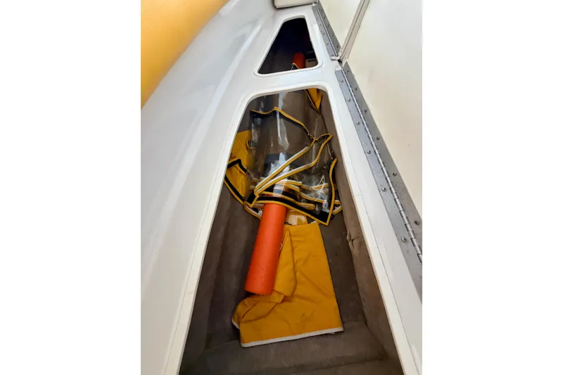 Slide: The Image of Storage compartment in a 2006 Crownline 266 BR boat with orange and yellow gear. - 29
