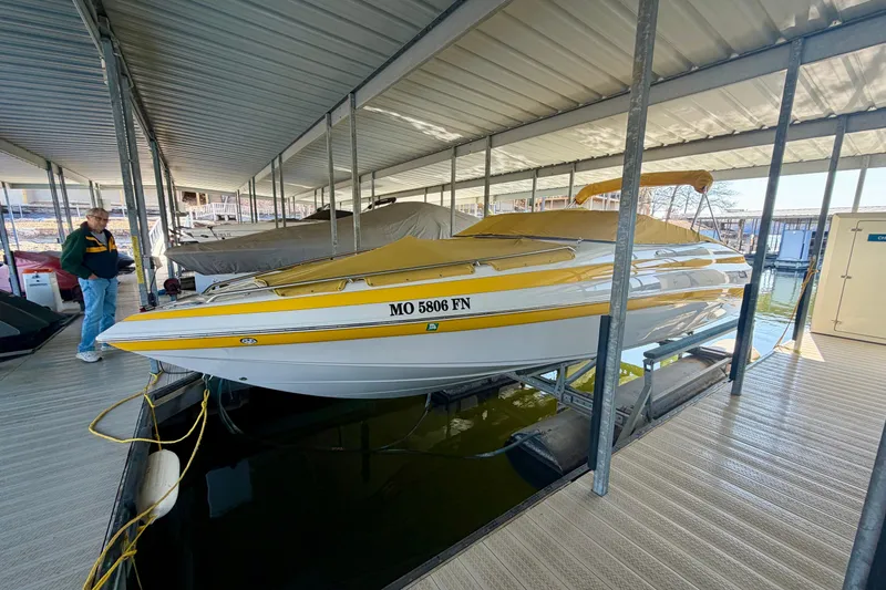 Slide: The Image of 2006 Crownline 266 BR boat in dock, covered and secured, with yellow accents. - 3