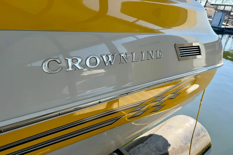 Slide: The Image of 2006 Crownline 266 BR boat with yellow and white exterior, docked on water. - 32