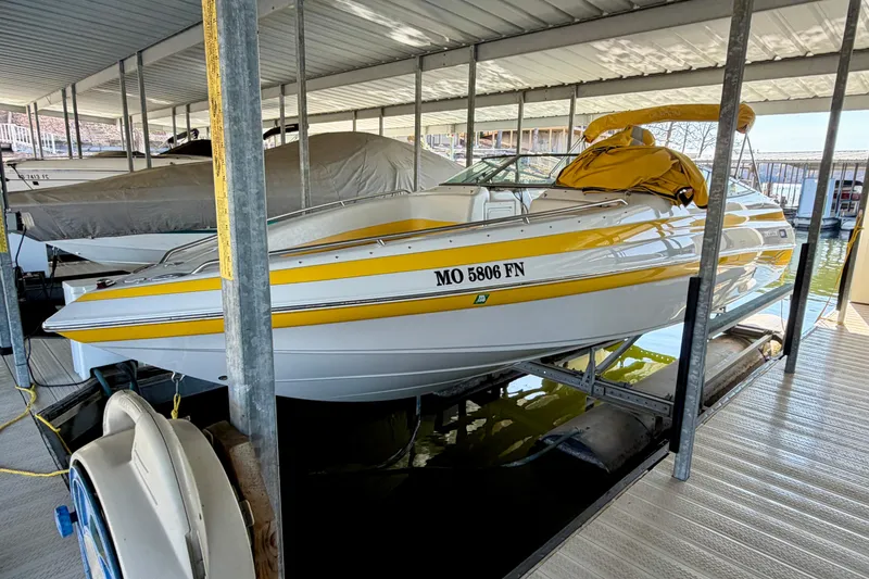 Slide: The Image of 2006 Crownline 266 BR boat with yellow accents docked in a covered marina. - 4