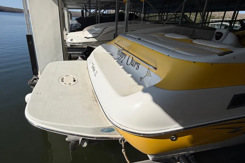 Slide: The Image of 2006 Crownline 266 BR boat docked, featuring yellow and white design, rear view. - 5