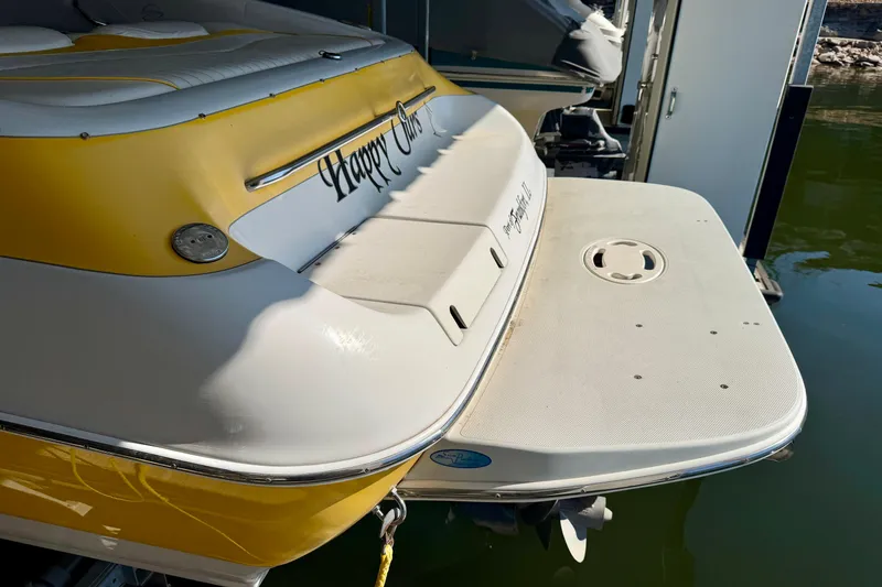 Slide: The Image of 2006 Crownline 266 BR boat with yellow and white exterior, docked near water. - 6