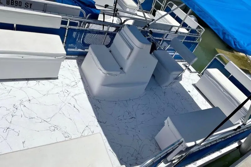 Slide: The Image of Pontoon boat interior with white seating, marble-patterned flooring, and blue canopy, A&M Manufacturing 2021. - 6