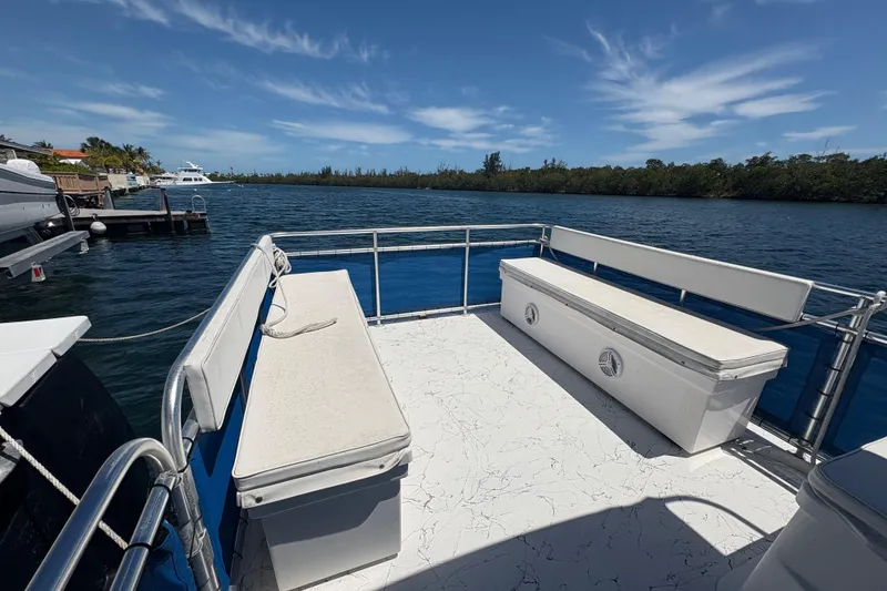 Slide: The Image of A&M Manufacturing 2021 Salty boat deck with benches, docked by a scenic waterway. - 12
