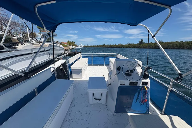 Slide: The Image of 2021 A&M Manufacturing Salty boat with blue canopy on calm water. - 14