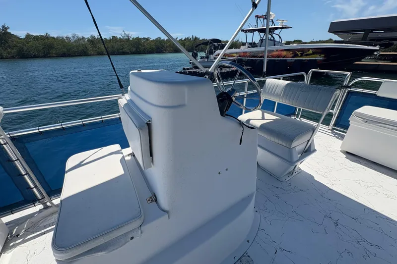 Slide: The Image of 2021 A&M Manufacturing Salty boat interior with steering wheel and seating on a sunny day. - 16