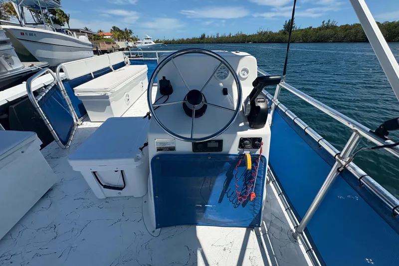 Slide: The Image of 2021 A&M Manufacturing Salty boat helm with steering wheel and controls on a sunny day. - 17