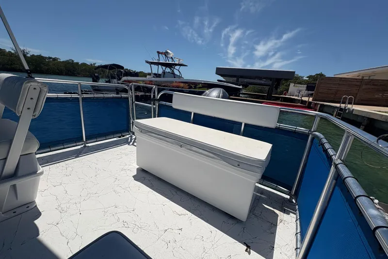 Slide: The Image of Pontoon boat deck with seating, A&M Manufacturing Salty 2021, docked by the water. - 21