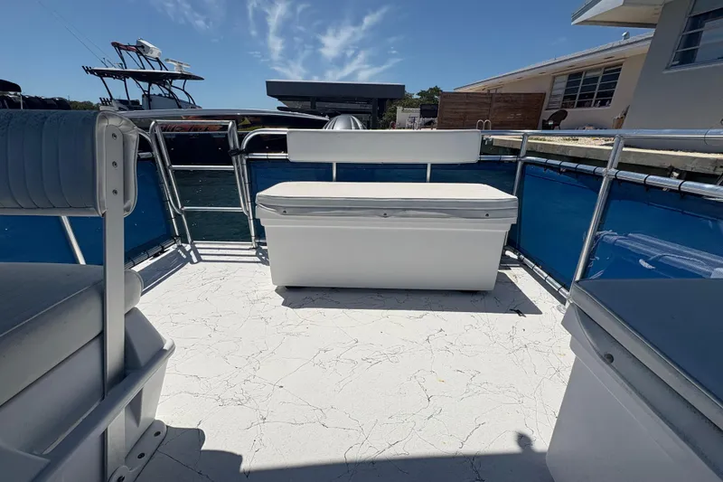 Slide: The Image of Pontoon boat deck with seating, A&M Manufacturing Salty 2021 model, docked under clear sky. - 23