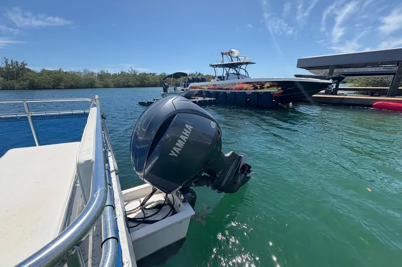 Slide: The Image of Boat docked with Yamaha motor, A&M Manufacturing Salty 2021 model, sunny day on the water. - 24