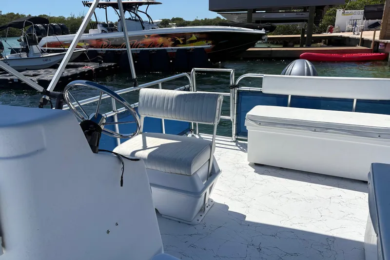Slide: The Image of Pontoon boat interior by A&M Manufacturing, model Salty, 2021, docked near other boats. - 31