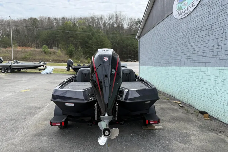 Slide: The Image of 2026 iKon vls20 boat with outboard motor parked near a marine shop. - 5