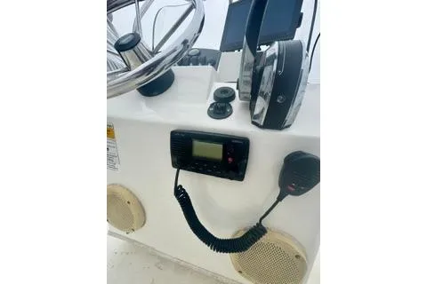 Slide: The Image of 2014 Boston Whaler Montalk boat dashboard with steering wheel and communication equipment. - 12