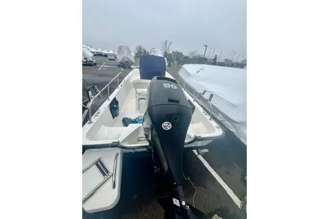 Slide: The Image of 2014 Boston Whaler Montalk boat with outboard motor in a parking lot. - 8