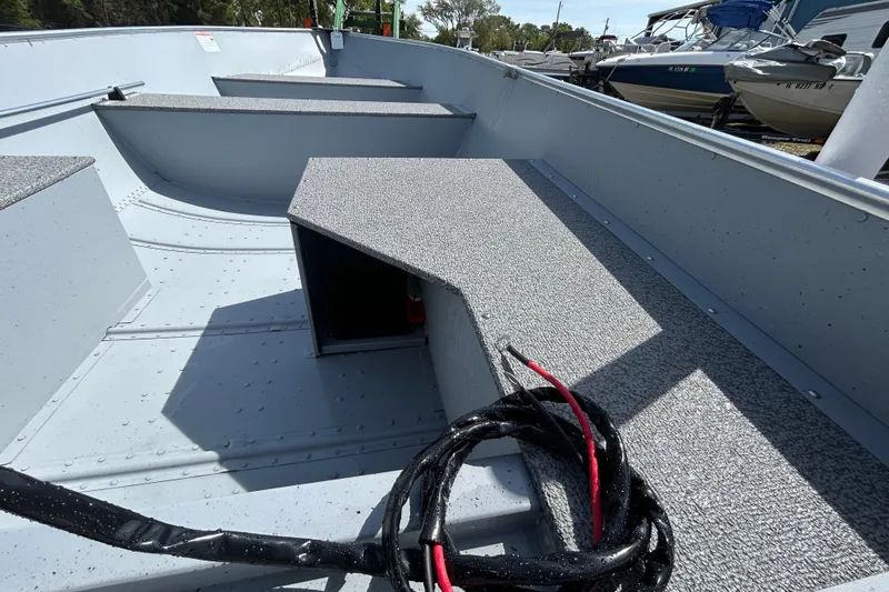 Slide: The Image of 2026 Crestliner 1469 Outreach boat interior with storage compartments and coiled cables. - 10