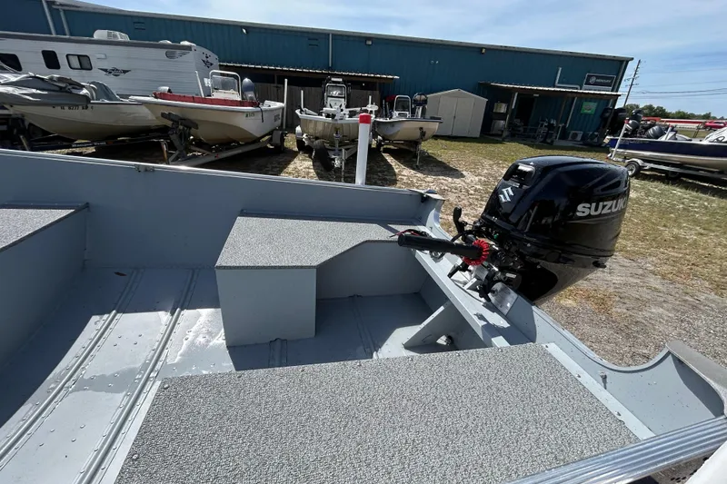 Slide: The Image of 2026 Crestliner 1469 Outreach boat with Suzuki outboard motor in a dealership lot. - 11