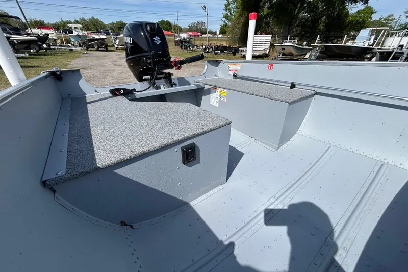 Slide: The Image of 2026 Crestliner 1469 Outreach boat interior with Suzuki outboard motor, parked outdoors. - 7