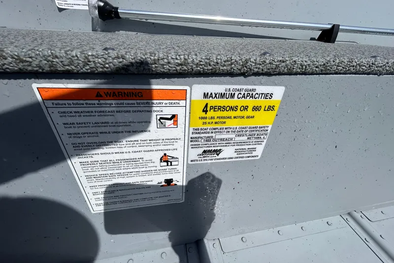Slide: The Image of 2026 Crestliner 1469 Outreach boat warning labels, showing maximum capacity and safety instructions. - 8