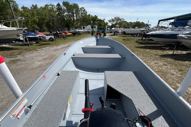 Slide: The Image of 2026 Crestliner 1469 Outreach boat in a marina, surrounded by various watercraft. - 9