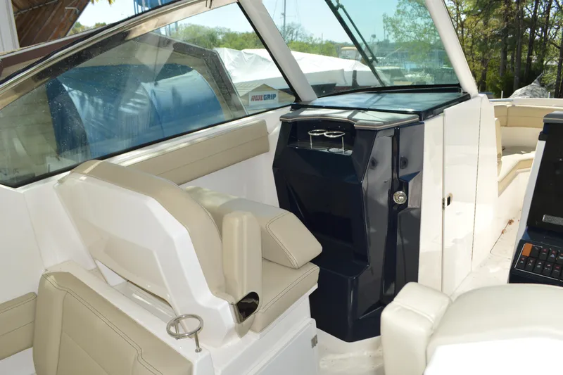 Slide: The Image of 2018 Pursuit DC 295 Dual Console interior with beige seating and sleek dashboard design. - 12