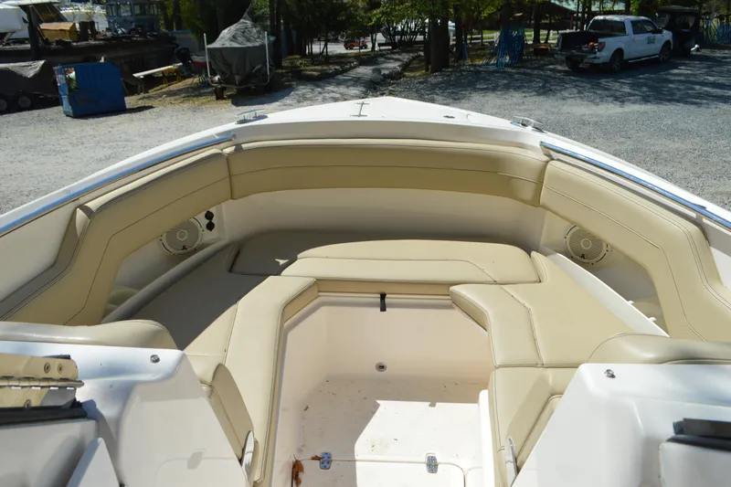 Slide: The Image of 2018 Pursuit DC 295 Dual Console boat with beige seating in a marina setting. - 13