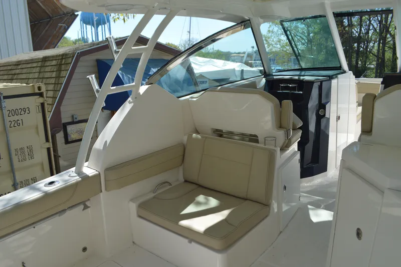 Slide: The Image of 2018 Pursuit DC 295 Dual Console boat interior with beige seating and modern design. - 15